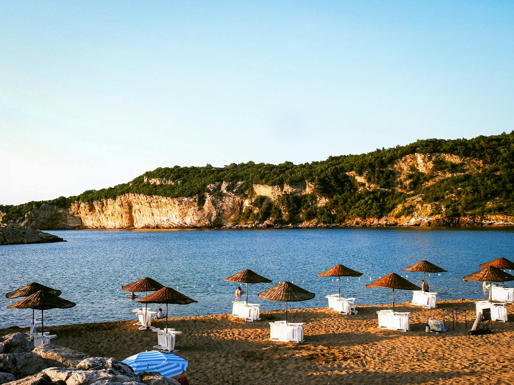 Plaża w Turcji z parasolami i skalistym klifem nad morzem