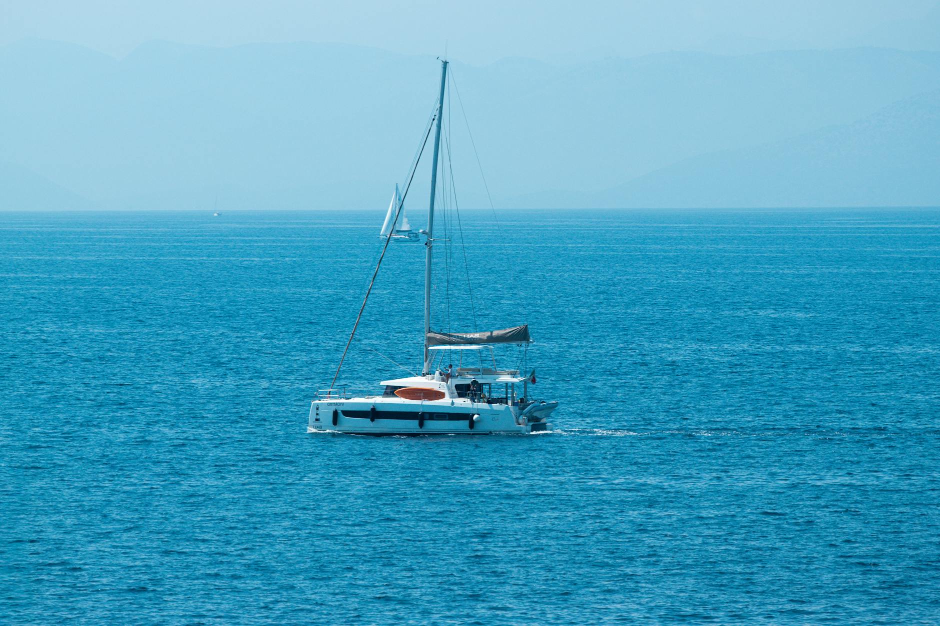 Żaglówka na turkusowym morzu u wybrzeży greckiej wyspy