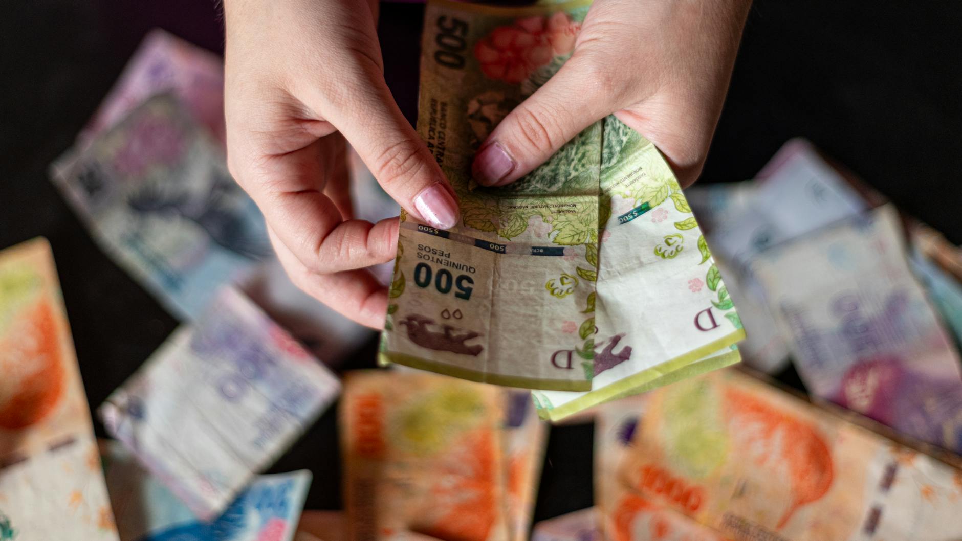 Dłonie liczące banknoty obcej waluty z bliska