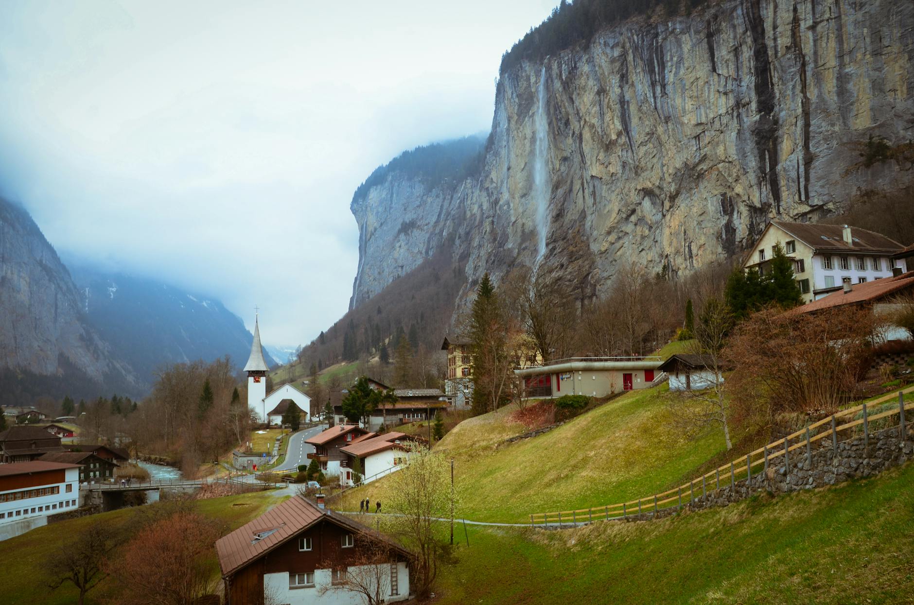 Dolina Lauterbrunnen z wodospadem, wioską i wysokimi klifami w Szwajcarii