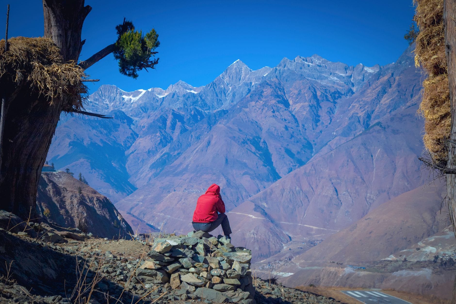 Samotny turysta w czerwonej kurtce podziwia Himalaje w Nepalu