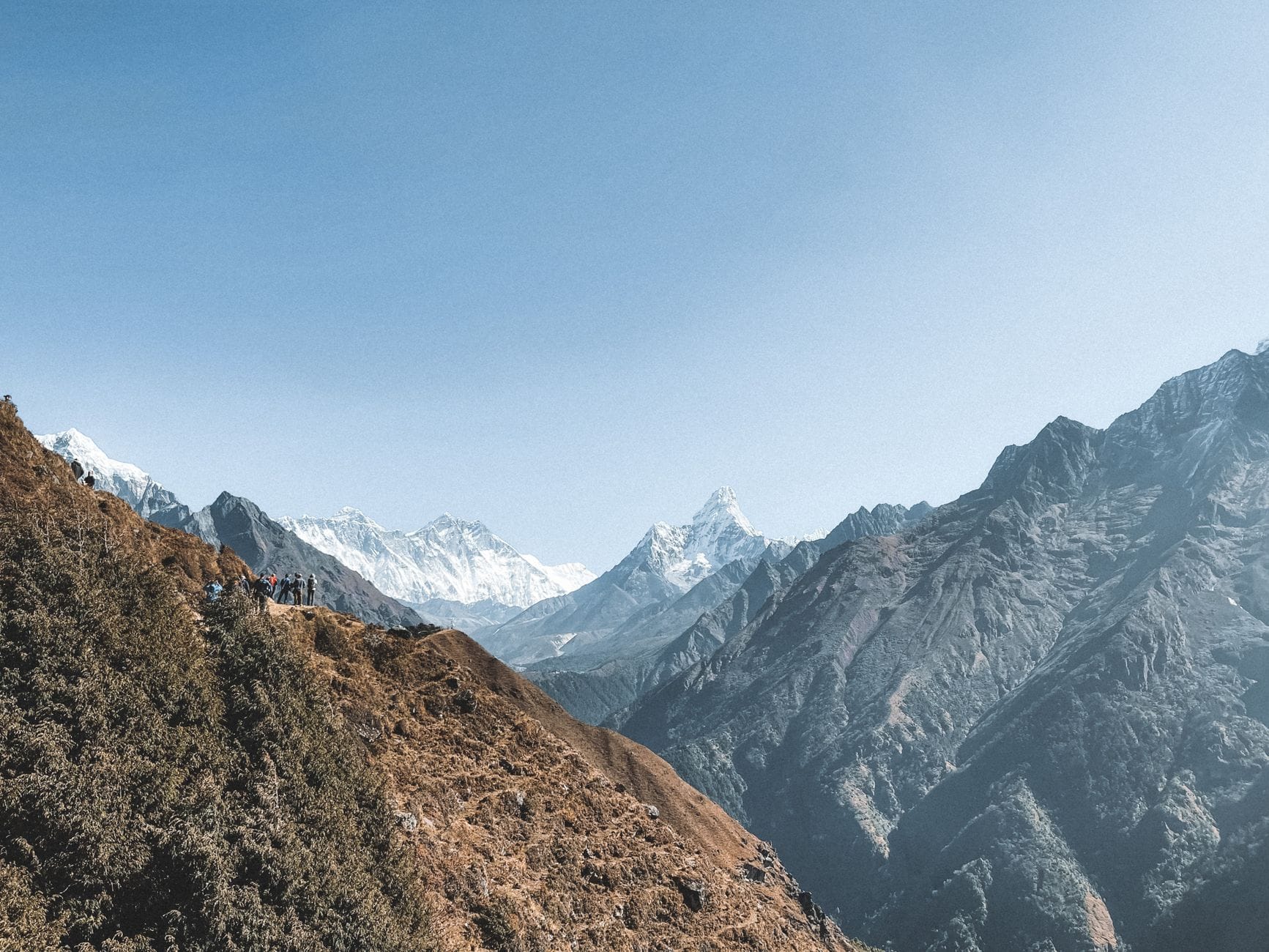 Turyści na górskim szlaku z widokiem na Himalaje w Nepalu